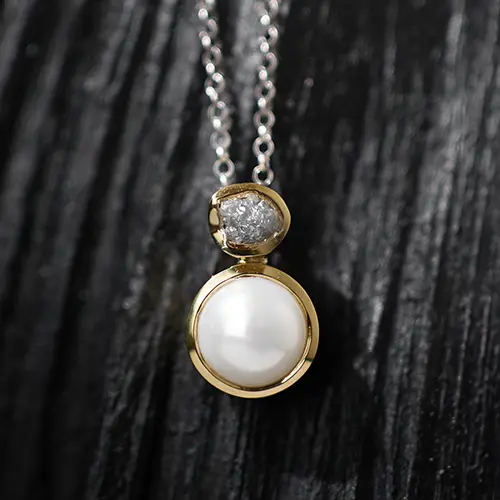 Silver ring with a pearl pendant